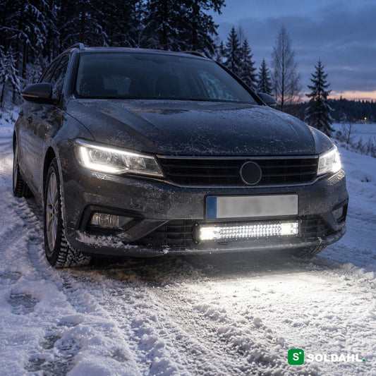 LED-valopaneeli asennettuna auton puskurin alle lumisella tiellä hämärässä