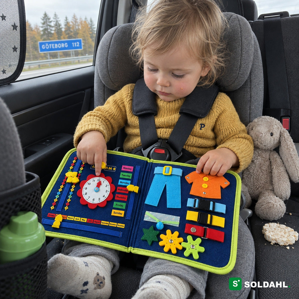 Kaksivuotias turvaistuimessa kääntää toimintakirjan kelloa automatkalla