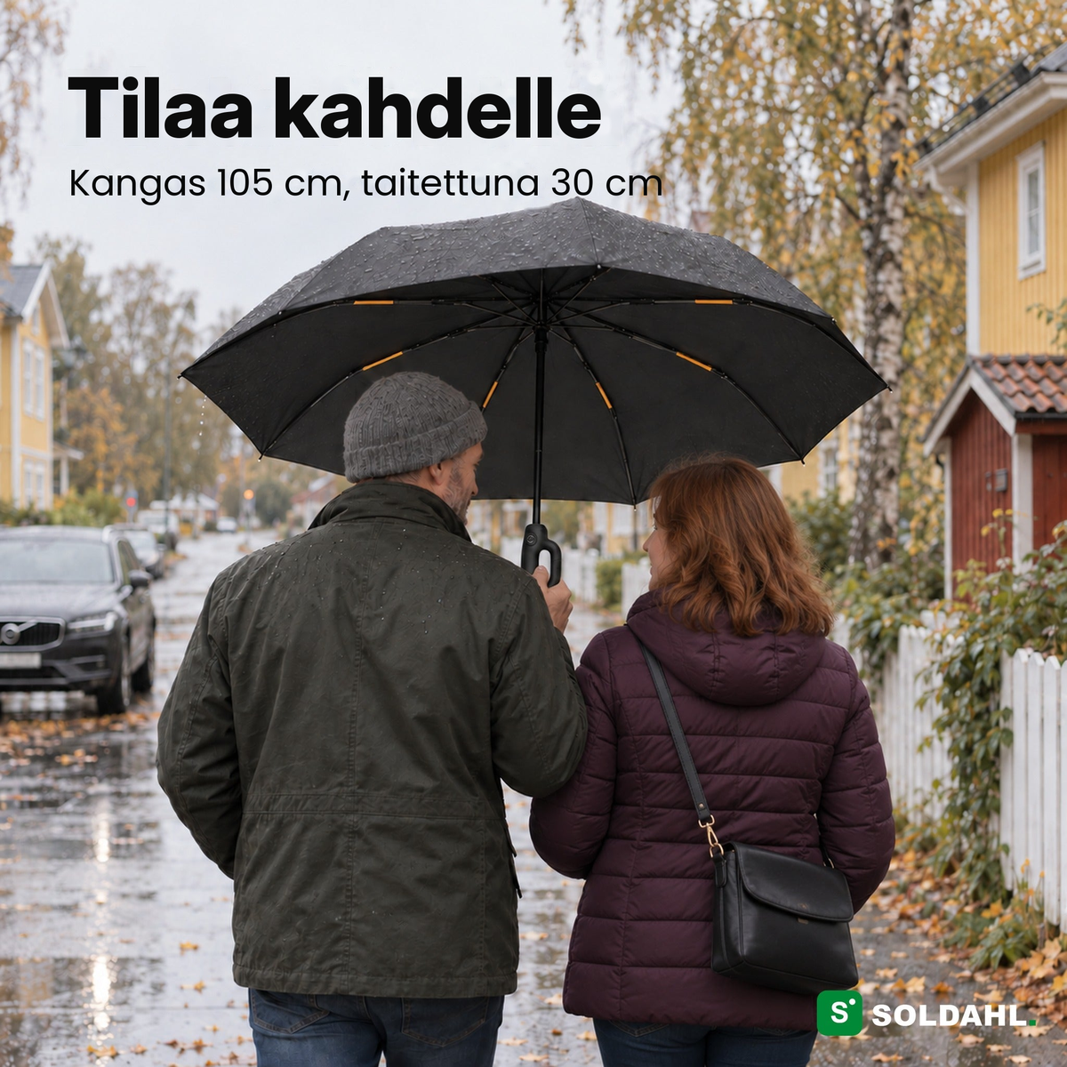 Kaksi aikuista kävelee yhdessä Myrskysateenvarjon alla sateisella omakotitalokadulla