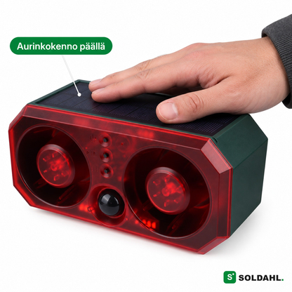 Käsi lepää Vildron päällä olevalla aurinkokennolla, kaksi punaista torvikaiutinta ja tunnistin